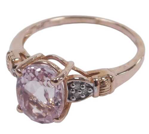 A 9ct rose gold and kunzite solitaire ring, high claw set, with diamond set shoulders, size O&frac12;,...
