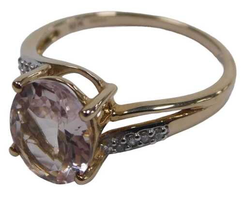 A 9ct gold morganite and diamond ring, the oval cut morganite in a high claw setting, with...