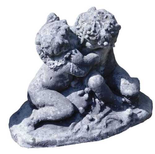 A concrete garden ornament of a pair of frolicking putti, modelled seated, on an oval base, 64cm...