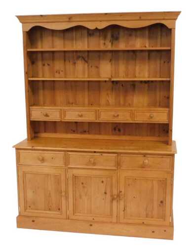 A pine dresser, the outswept pediment over a plate rack with three shelves over four short...