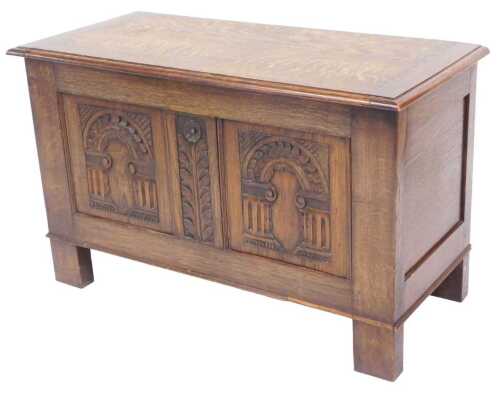 A 17thC style oak blanket chest, the hinged lid over a front panel carved with window arches...