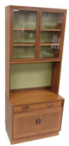 A G-Plan teak lounge unit, with a display cabinet with glass doors enclosing two shelves, above...