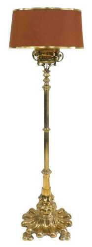 A Victorian brass standard oil lamp, converted to electricity, with a brass reservoir, above a...