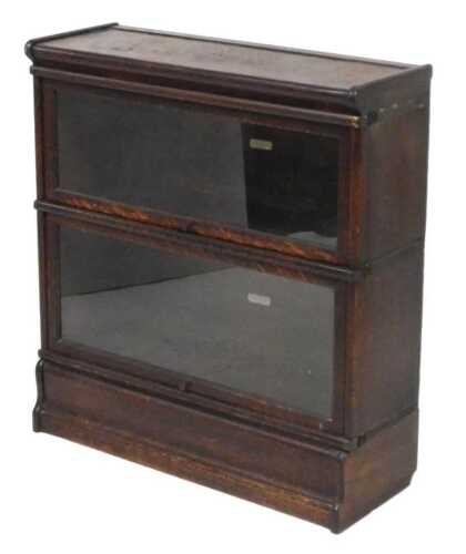 A Victorian oak Globe-Wernicke bookcase, with two glazed up and over doors, raised on a shaped...