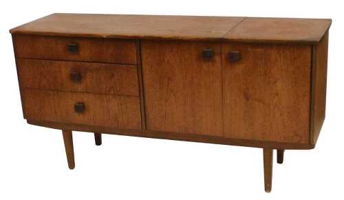 A 1960s teak sideboard, with three graduated drawers to the left, flanked by a pair of cupboard...