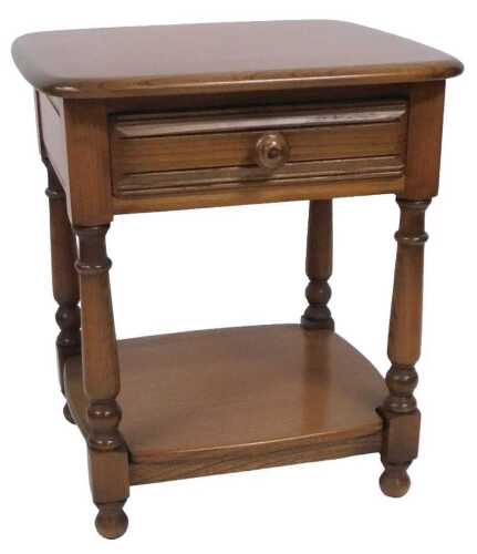 An Ercol elm occasional table, with a rounded square top over a single frieze drawer, raised on...
