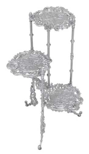 A silvered metal three tier pan stand, embossed with birds, flowers and foliate scrolls, raised...