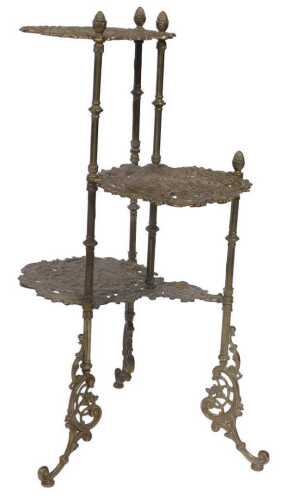 A brass three tier pan stand, embossed with birds, flowers and foliate scrolls, raised on four...