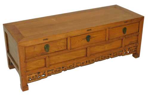 A Japanese elm low chest, with three frieze drawers and an interior recess, raised on scroll...