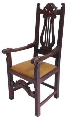 A Victorian oak carver chair, with a carved crest rail, above a lyre shaped splat, with floral...