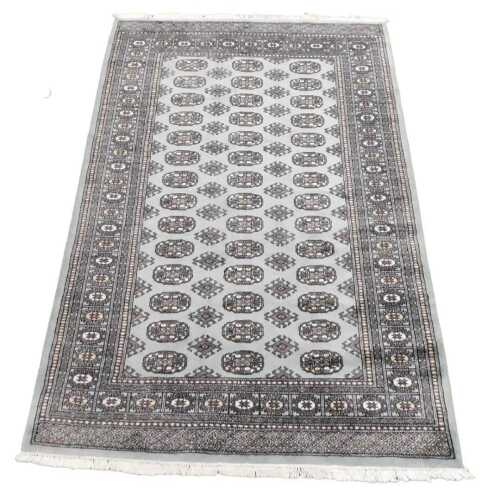 A Bokhara turquoiuse ground rug, the central field with three rows of fourteen medallions,...