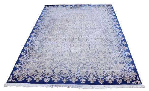 A European cream and blue ground rug, decorated with stylised flowers and scrolling leaves,...