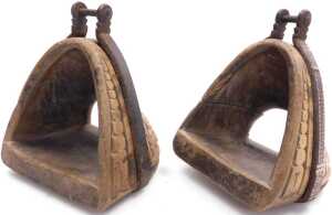 A pair of 19thC Chilean carved wooden huaso stirrups, each with iron mounts, decorated with a... - 2