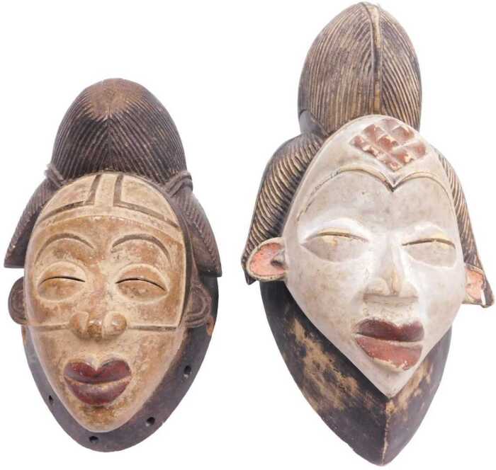A Gabonese Punu tribal mask, with a cream painted face embellished in red and pink, 32cm high,...