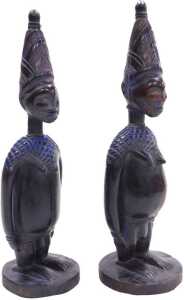 A pair of African Yoruba fertility figures, each with a tapering hat, and circular base,...