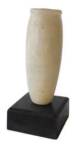An Egyptian alabaster funerary vase, of cylindrical form, on an ebonised base, 18cm high....