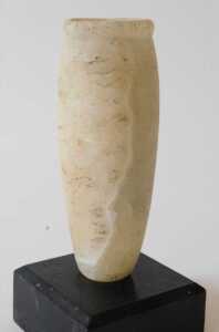 An Egyptian alabaster funerary vase, of cylindrical form, on an ebonised base, 18cm high.... - 2