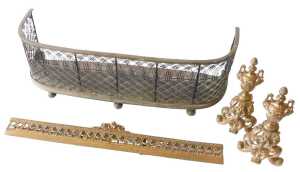 A French gilt metal fender, comprising of two chenet with urns and scrolls, and a centre carpet...