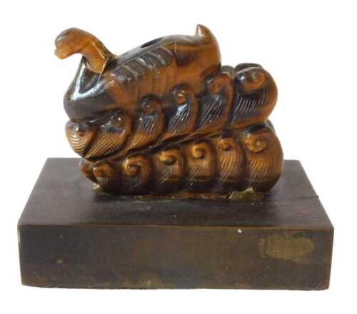 A heavily carved Chinese tiger's eye snuff bottle, profusely decorated, lacking stopper, on...