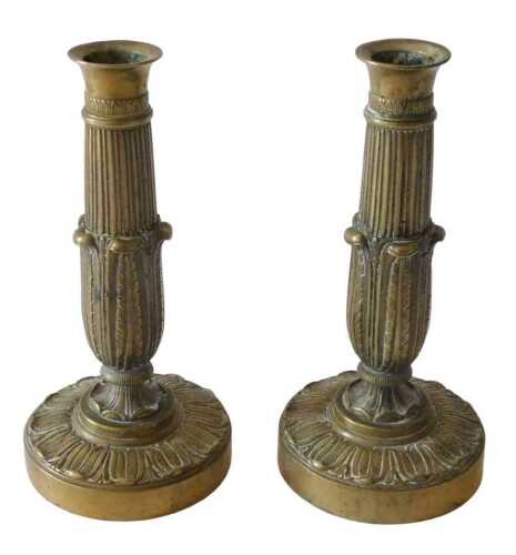 A pair of 19thC French Empire brass candlesticks, each with fluted and acanthus leaf stems, on...