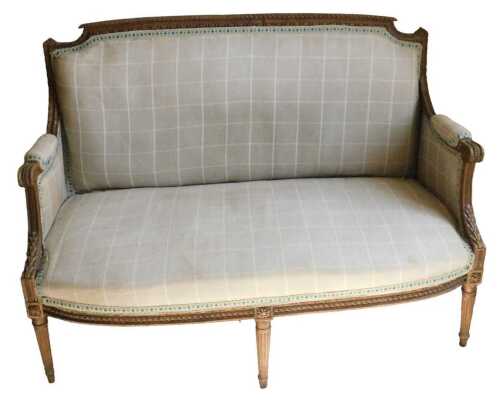 A Louis XVI French beech settee, with a heavily carved outline, inverted scroll arms, with...