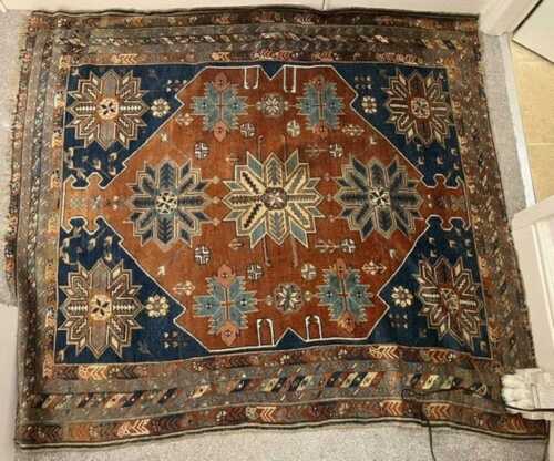 A Persian Kazak style rug, the outer field with a repeat geometric and floral border,...