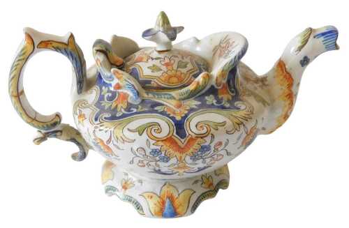 A late 19th French Rouen faience polychrome decorated teapot, profusely set with panels of...