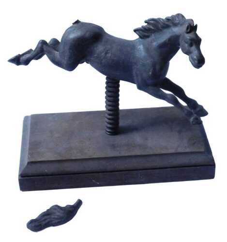 A 19thC cast iron toy horse, mounted on a spring, with rectangular wooden plinth, 26cm high,...