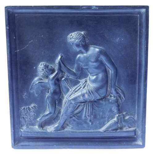 A composition square plaque, decorated in the Neoclassical style with a nude female and a cherub,...
