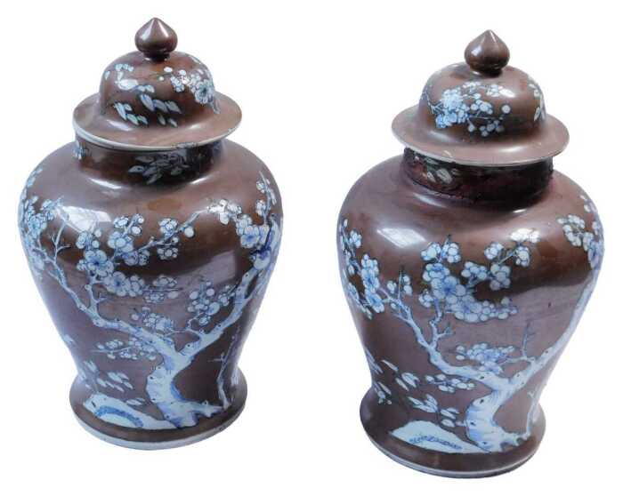 A pair of Chinese Kangxi chocolate ground porcelain vases and covers, each decorated with...