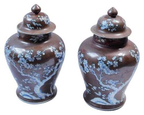 A pair of Chinese Kangxi chocolate ground porcelain vases and covers, each decorated with...