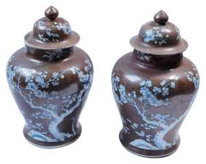 A pair of Chinese Kangxi chocolate ground porcelain vases and covers, each decorated with...
