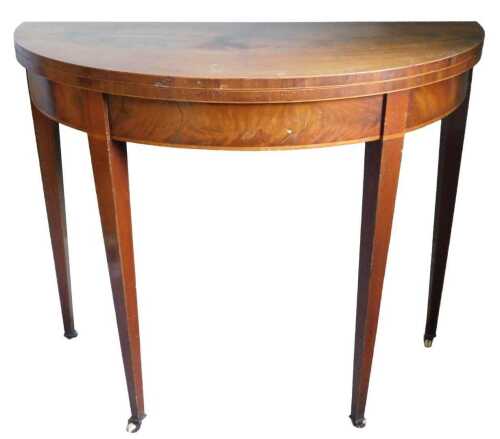 An early 19thC mahogany boxwood strung D shaped card table, the hinged top revealing a baize...