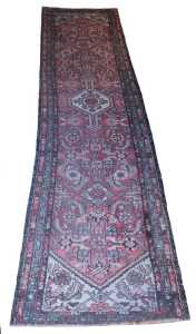 A Persian runner, with a central cream pole medallion, on a red ground decorated with roundels,...