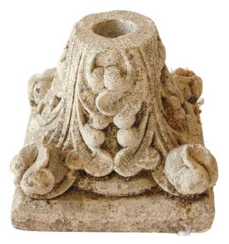 A composition candlestick, modelled in the form of a column capital, decorated with flowers and...