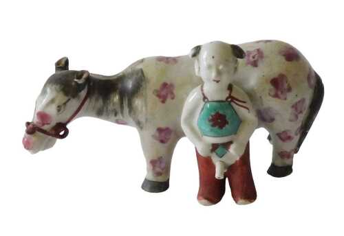 A Chinese porcelain figure of a pink spotted horse or mule, beside a ?? figure, 19cm long....