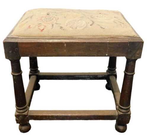 A 19thC oak stool, the padded seat with a floral embroidered needlework padded seat, on turned...