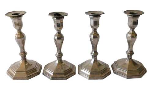 A set of four early 20thC silver-plated candlesticks, with octagonal urn sconces, on inverted...