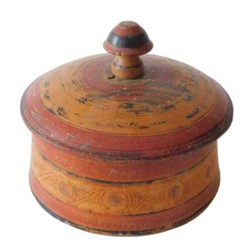An Indian spice box, of circular form, with domed lid and turned knop, in a red and geometric...