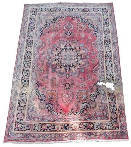A 20thC machine woven rug, of rectangular form, with geometric floral pattern, predominantly in...
