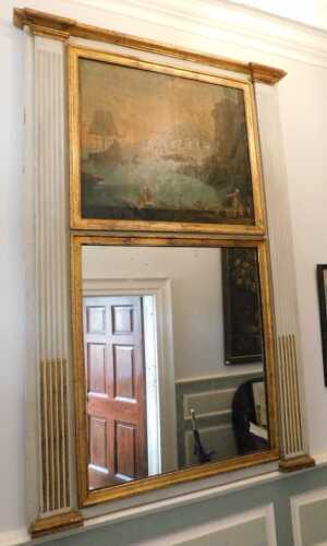 An early 19thC gilt and green painted overmantel mirror, the inverted breakfront cornice above a...