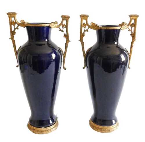 A pair of French blue glazed vases, each with gilt metal mounts, embellished with leaves and...