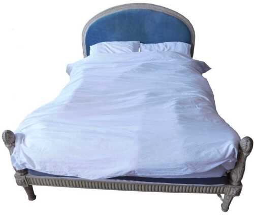 A French dark cream painted kingsize bed, the arched, moulded and carved headboard with a blue...