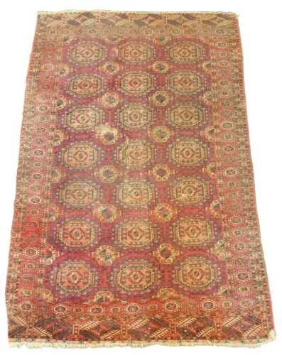A Tekke Turkoman rug, with a design of medallions in red, with one wide border and multiple...