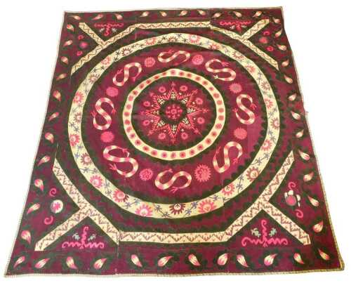 An Eastern Suzani, made and embroidered in sections, with a design of a central roundel, within...
