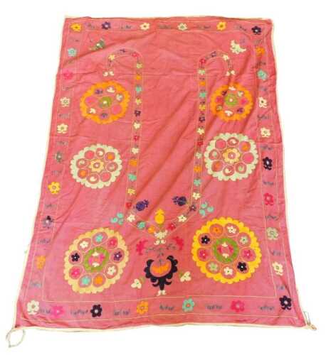 An Eastern Suzani prayer rug, with a central mihrab surrounded by medallions in gold, green,...