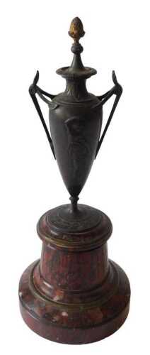 A French bronzed spelter and marble two handled urn, of tapering form, cast with Neoclassical...