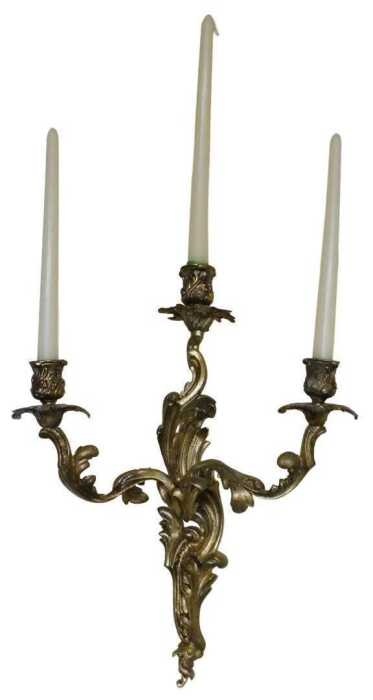 A pair of late 19thC Louis XV style rococo style gilt metal three-branch wall sconces, each with...