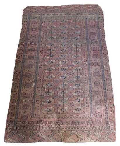 A Tekke Turkoman rug, with a design of three rows of medallions, on a red ground, with multiple...