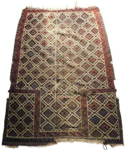 A Turkoman prayer rug, with a design of lozenges, in red, navy and dark brown, on a cream ground,...